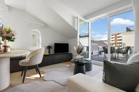 Stylishes Hotelzimmer mit gemütlichem Sitzbereich und Blick auf den Balkon im Hotel Stadt Hamburg.