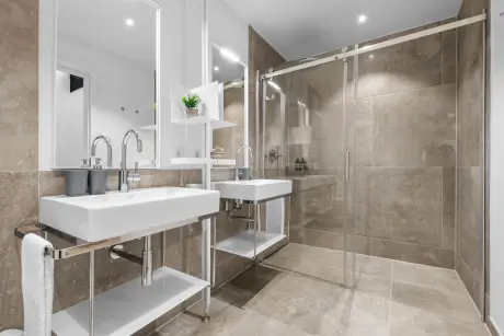 Modernes Badezimmer mit Glasdusche und zwei Waschbecken im Hotel Stadt Hamburg.