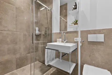 Badezimmer im Hotel Stadt Hamburg mit Dusche, Waschbecken und modernen Akzenten.