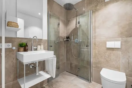 Modernes Badezimmer im Hotel Stadt Hamburg mit Dusche, Waschbecken und Toilette.