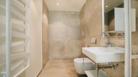 Elegantes Badezimmer mit Dusche, Waschbecken und moderner Toilette im Hotel Stadt Hamburg.