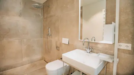 Modernes Badezimmer mit Dusche, Waschbecken und WC im Hotel Stadt Hamburg in Westerland.