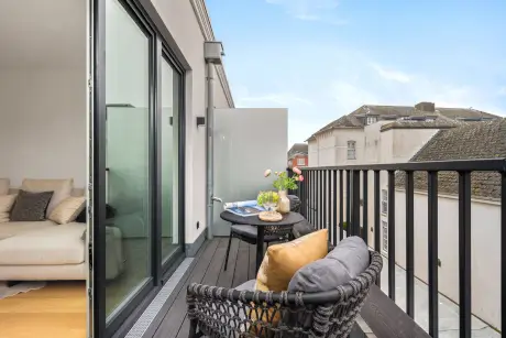 Moderne balkon mit Tisch, Blumen und Blick auf die Umgebung.