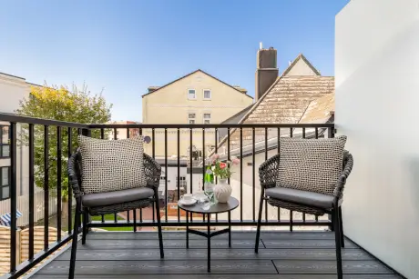 Außenbalkon im Hotel Stadt Hamburg mit stilvollen Stühlen und Blumen.