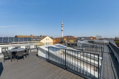 Blick vom Dachterrasse über Westerland mit typischen Gebäuden und einem Aussichtsturm.