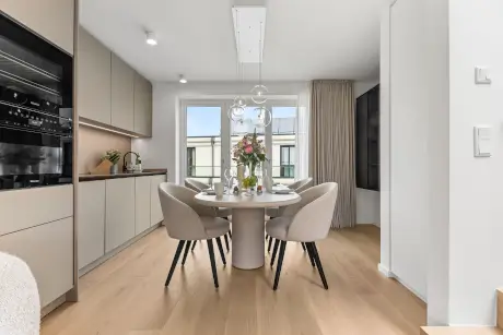 Stylischer moderner Essbereich mit Tisch und Stühlen, ideal für Hotelinterieurs.