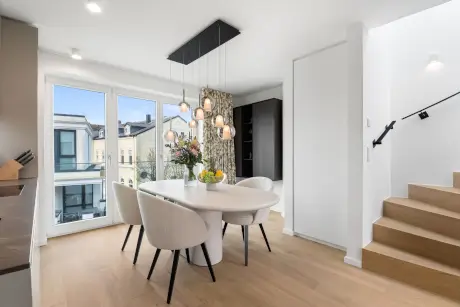 Moderne Hotel-Suite mit stilvollem Essbereich und Treppe.