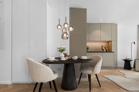 Moderne Hotel-Dinner-Ecke mit stilvollem Tisch und dekorativen Pendelleuchten.