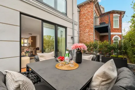 Gemütlicher Esstisch im Freien mit Blumen, Getränken und einem einladenden Ambiente.