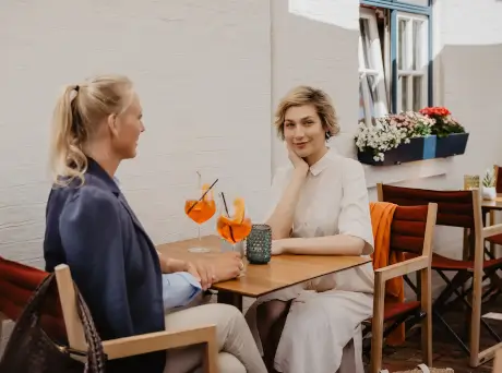 Zwei Frauen genießen Cocktails im Freien im Hotel Stadt Hamburg.