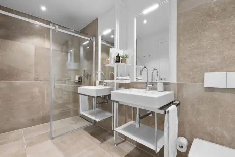 Modernes Badezimmer mit Dusche, Doppelwaschbecken und stilvollen Armaturen im Hotel Stadt Hamburg.