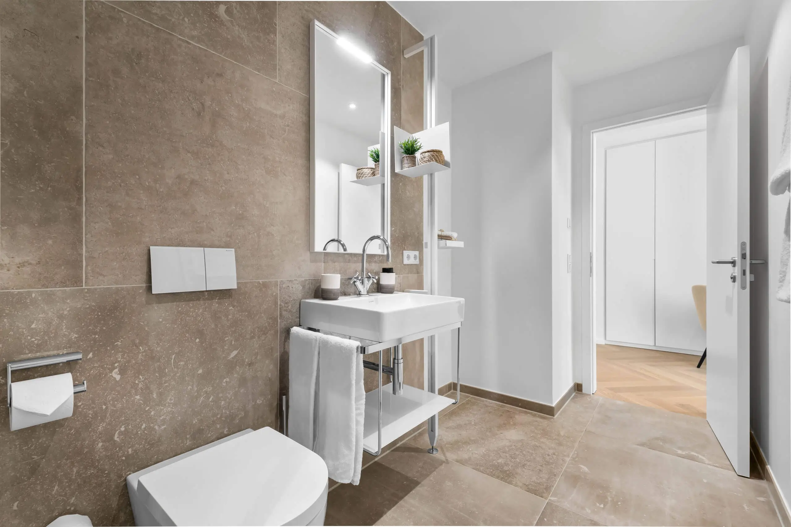 Modernes Badezimmer mit Waschbecken, Toilette und eleganter Ausstattung.