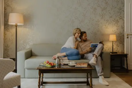 Ein Paar genießt quality Zeit in einem gemütlichen Hotelzimmer, komplett mit Erfrischungen.