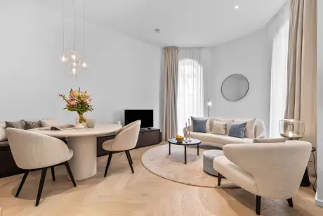 Moderne Wohnstube mit Sofa, runder Tisch und schöner Blumenarrangement.