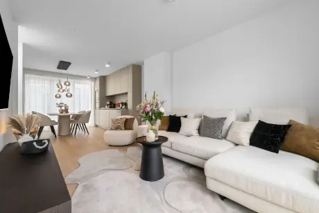 Modernes Wohnzimmer im Hotel Stadt Hamburg mit Sofa, Tisch und Blumenarrangement.