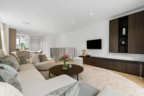 Modernes Wohnzimmer mit Sofa, Fernseher, Kaffeetisch und stilvoller Lampe.