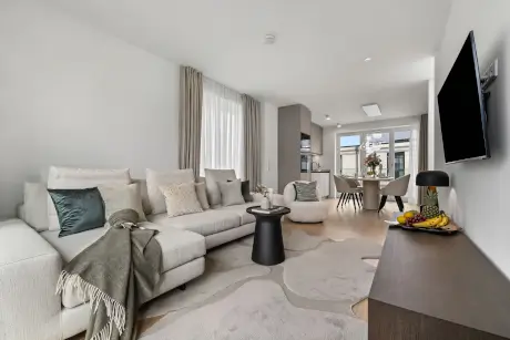 Moderne Hotel-Suite mit Sofa, Esstisch und stilvollem Dekor in Westerland.