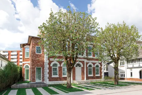 Schönes Backsteingebäude des Hotels Stadt Hamburg mit großen Fenstern und Bäumen.