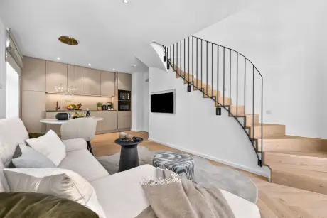 Elegante Wohnfläche mit modernem Küchenbereich und stilvoller Treppe im Hotel Stadt Hamburg.