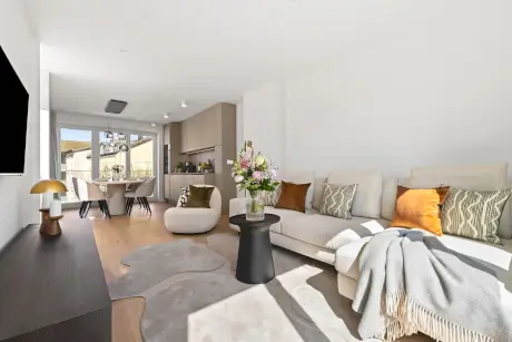 Moderne Hotelzimmer mit stilvollem Sofa, Esstisch und blühenden Pflanzen in Westerland.