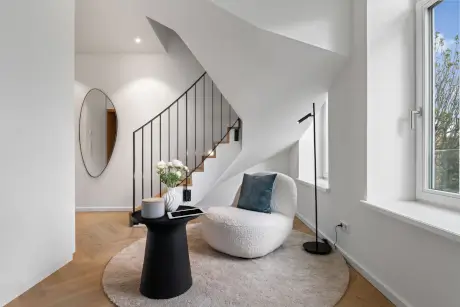 Helle Hotel-Lobby mit modernem Möbel-Design und frischen Blumen.