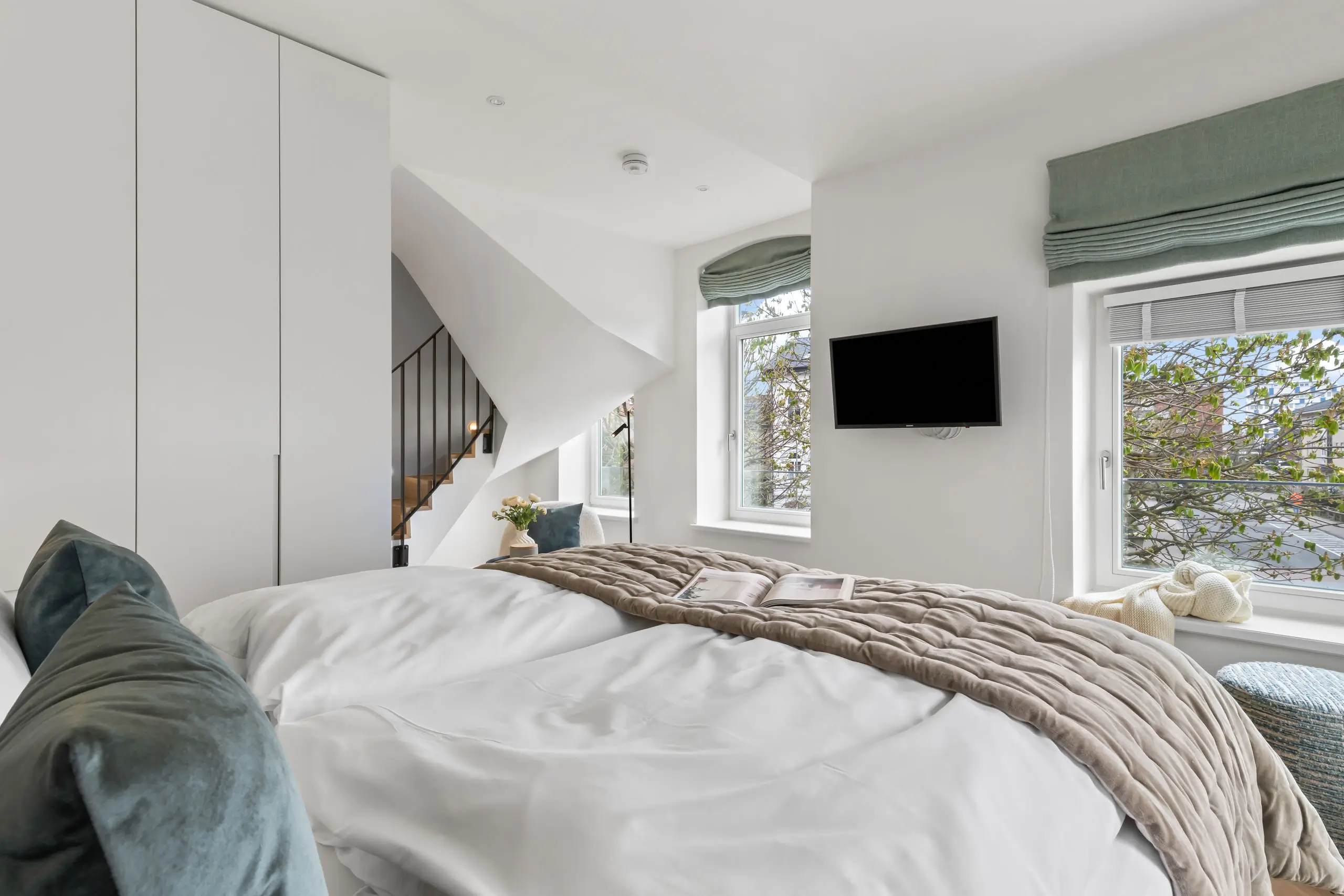 Modernes Schlafzimmer mit komfortablem Bett und Fernseher im Hotel Stadt Hamburg.