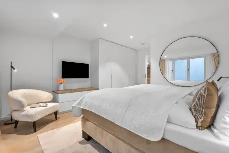 Modernes Hotelzimmer mit gemütlichem Bett, Stilvoller Stuhl und TV im 12.18. Hotel Stadt Hamburg, Westerland.