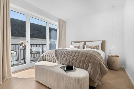 Luxus Schlafzimmer mit Bett, Tablet und Balkonblick im 12.18 Hotel Stadt Hamburg.