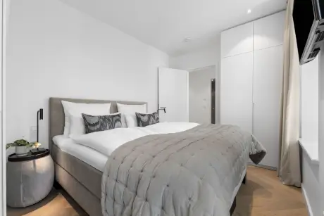 Elegantes Zimmer im Hotel Stadt Hamburg mit Bett, Fernseher und Kleiderschrank in Westerland, Sylt.