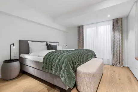 Moderne Hotelzimmer mit einem gemütlichen Bett und einem eleganten Fußbank.