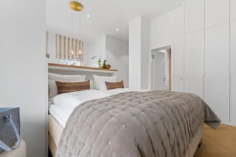 Elegantes Hotelzimmer mit komfortablem Doppelbett und stilvollen Lampen.