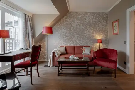 Elegante Hotelausstattung mit rotem Sofa und gemütlicher Atmosphäre im Hotel Stadt Hamburg.