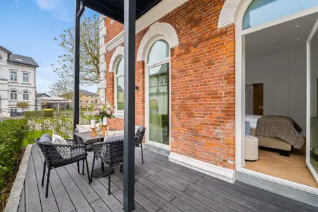 Terrasse mit Stühlen und Tisch hinter dem Hotel Stadt Hamburg, einladend und gemütlich.