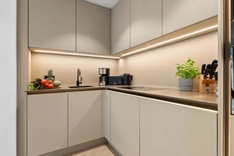 Moderne Küche mit frischem Obst, Kaffeemaschine und eleganten Geräten.