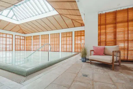 Luxuriöser Hotelpoolbereich mit modernen Sitzgelegenheiten und natürlichem Licht im Hotel Stadt Hamburg, Sylt.