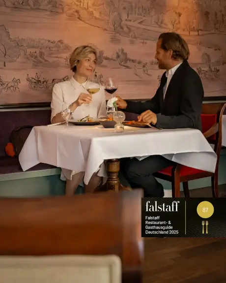 Ein Paar genießt ein elegantes Dinner in einem Restaurant mit Cocktails und Rotwein.