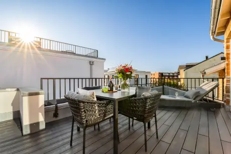 Terrasse mit Tisch, Stühlen und Blumen, ideal für sonnige Tage im Hotel Stadt Hamburg auf Sylt.