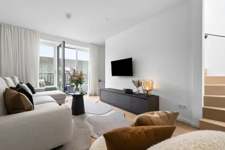 Stylisches Hotelzimmer mit Sofa, Fernseher und dekorativen Elementen.