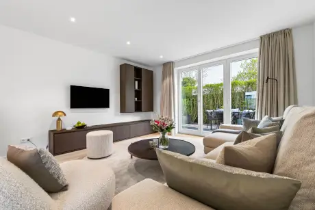 Gemütliches modernes Hotelzimmer mit Sofa, Couchtisch und Essbereich im Freien.